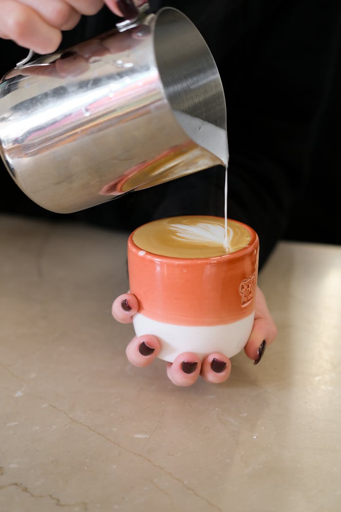 Close-up of a barista creating beautiful latte art in a cozy Istanbul cafe.